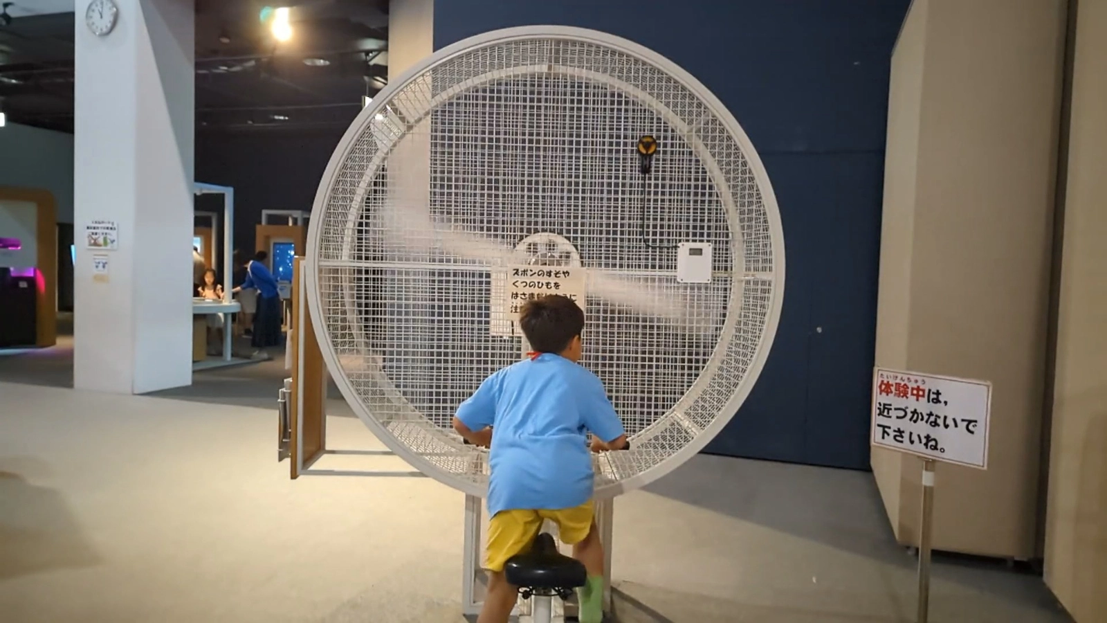 A young visitor rides the experiment bike exhibit at SciPal in Asahikawa Science Museum, learning about energy transfer and motion.