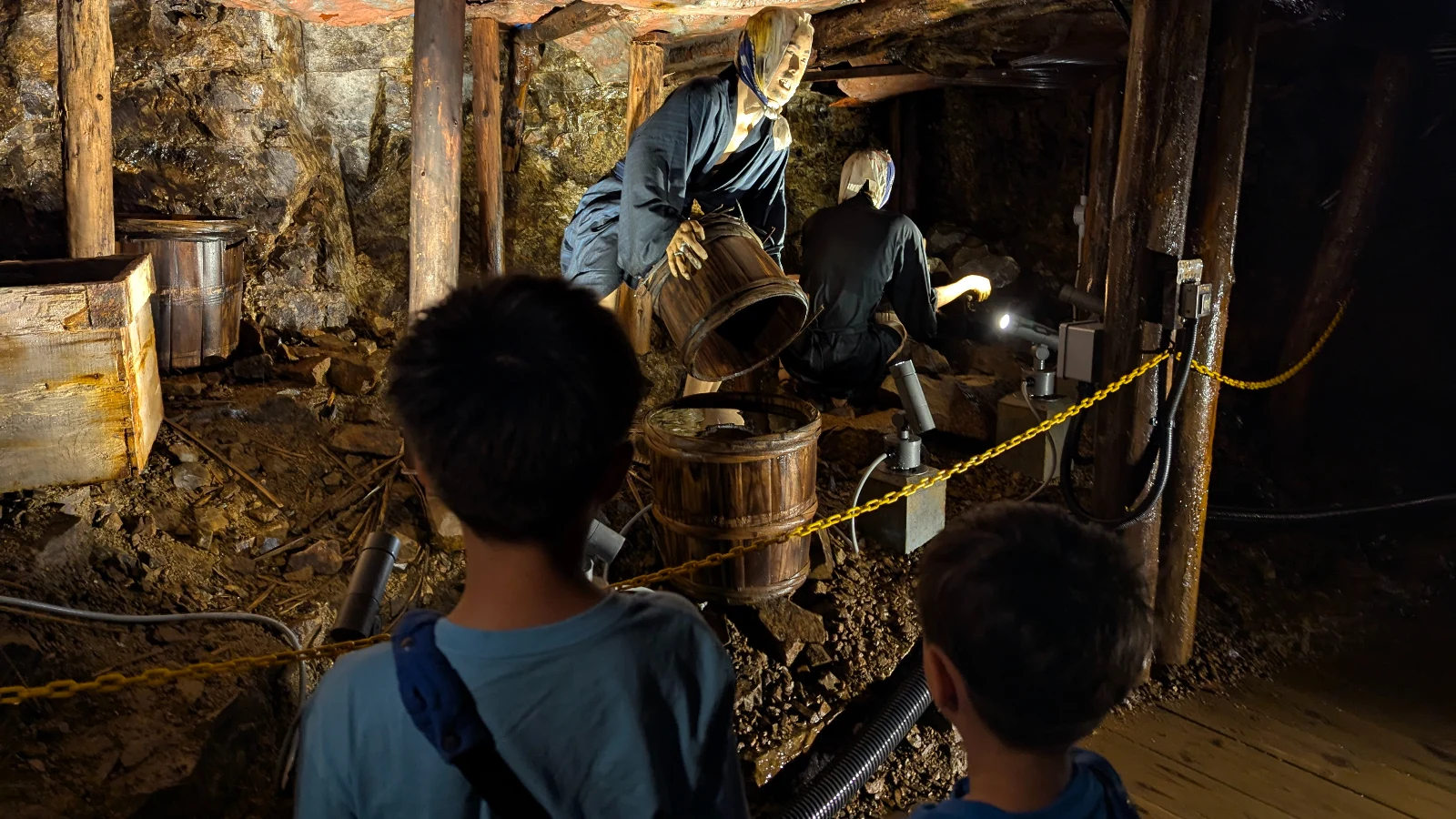 Kids observe lifelike miner figures working underground at the Ashio Copper Mine Museum, learning about Japan’s mining history.