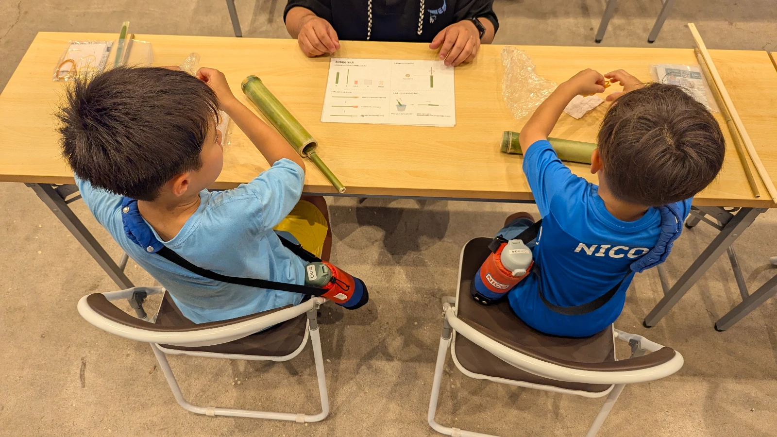 Children making bamboo crafts at Four Seasons Bamboo Forest Wakayama Farm in Tochigi, Japan, during a family-friendly workshop with local instructors.