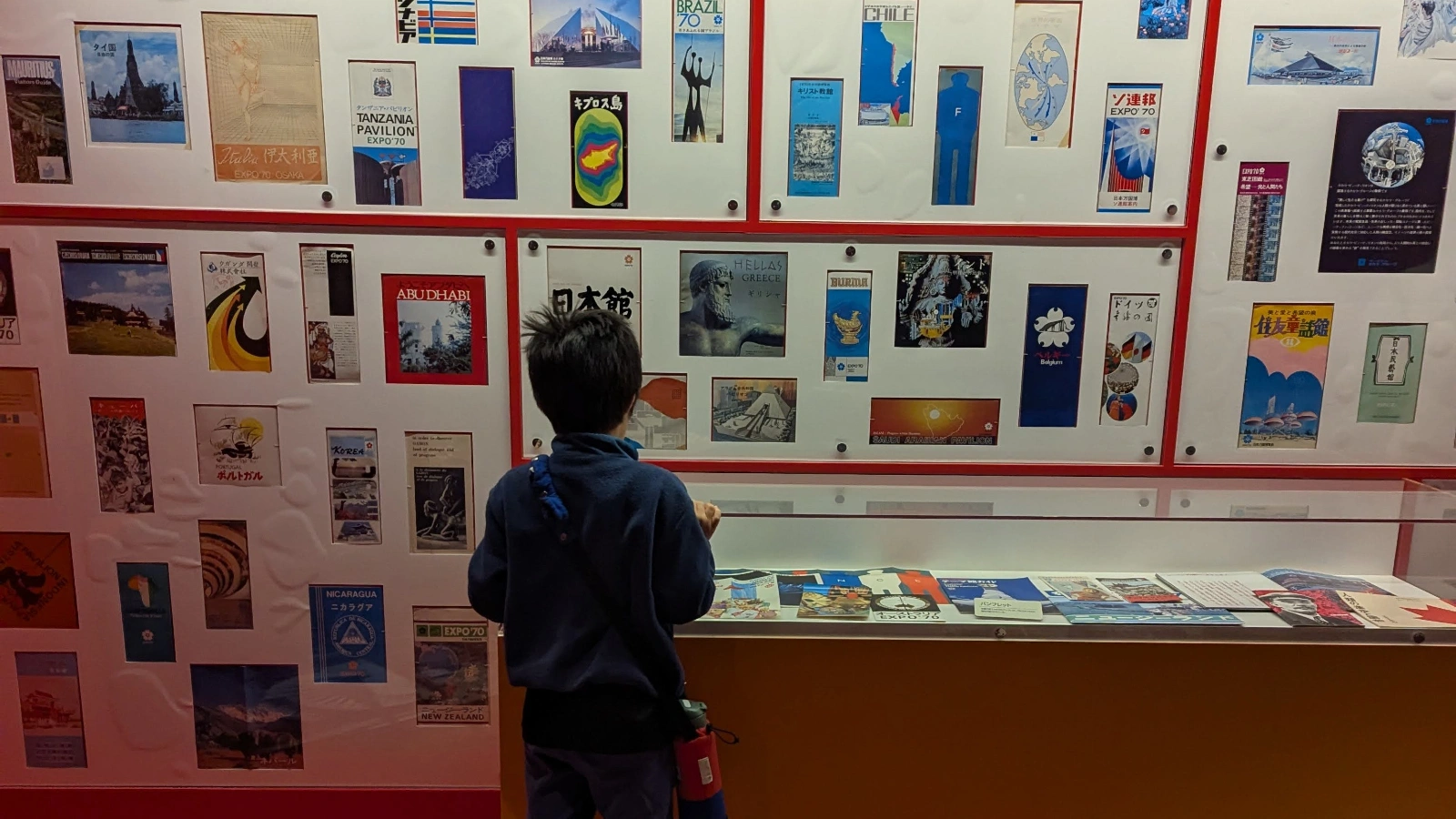 A young boy explores colorful vintage posters and exhibits from Expo ’70 at the Osaka Museum of Housing and Living. A family-friendly travel moment from the Osaka itinerary with kids.