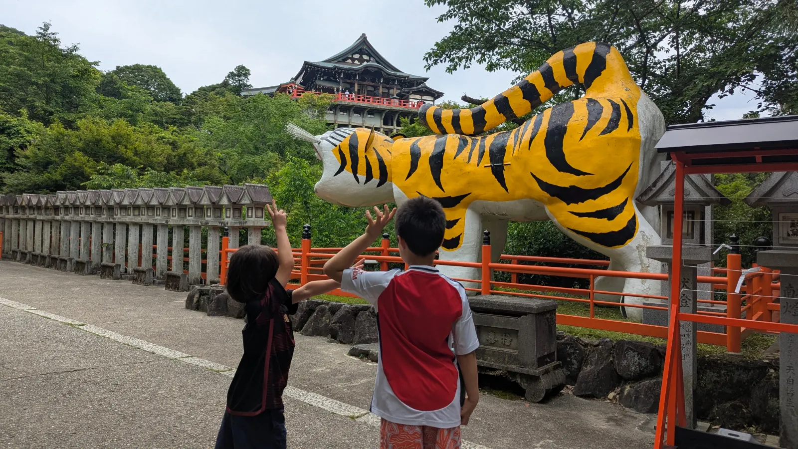 Luca and Nico looking up at the giant tiger statue at Chogosonshi-ji on Mount Shigi, Nara, Japan.