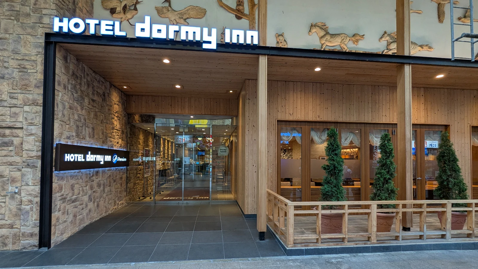 Entrance to Dormy Inn hotel in Japan with warm wooden design and signage, a popular choice for families.