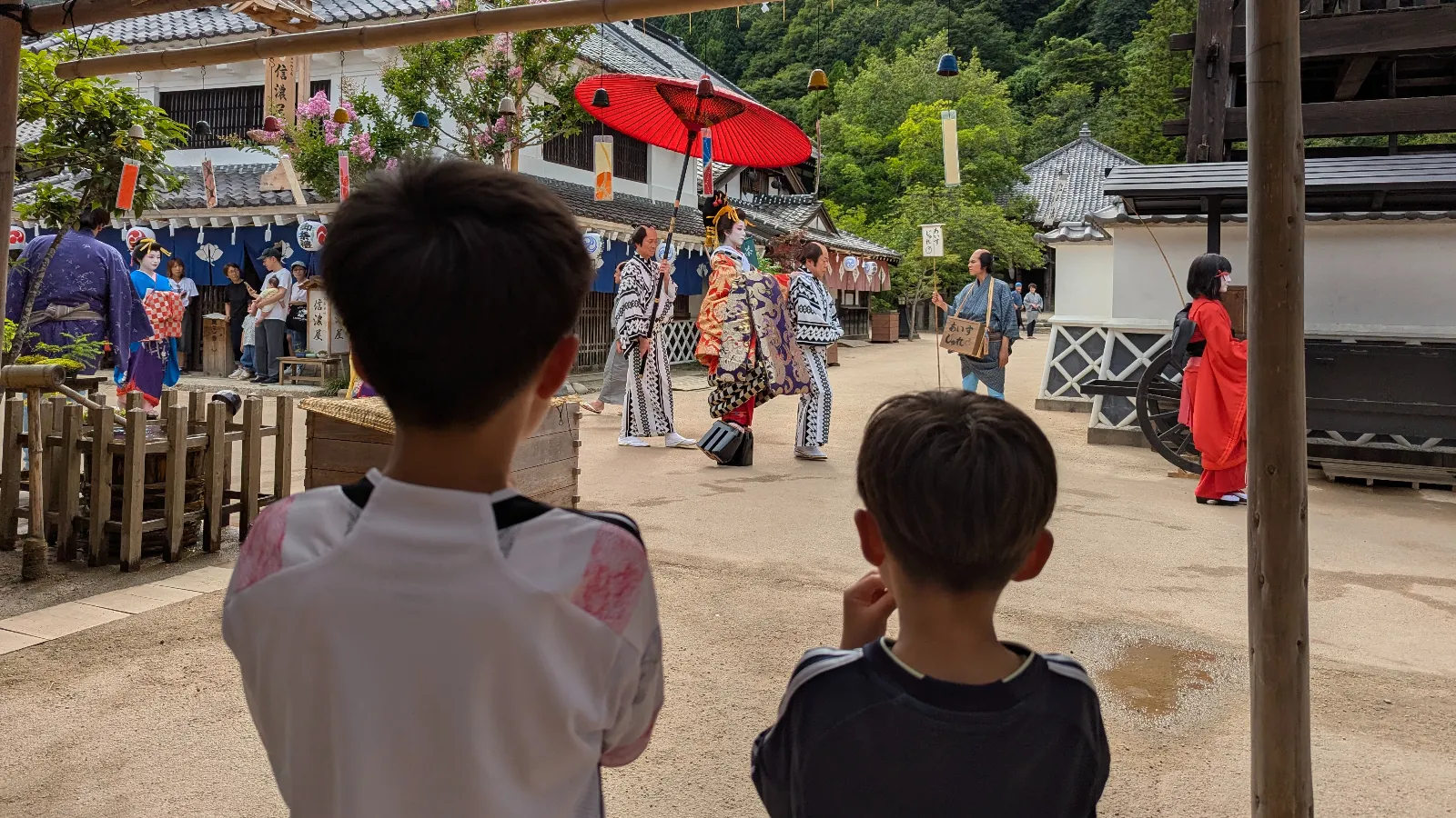 Children watching the Oiran Dochu parade at Edo Wonderland Nikko Edomura, a family-friendly samurai and ninja theme park.