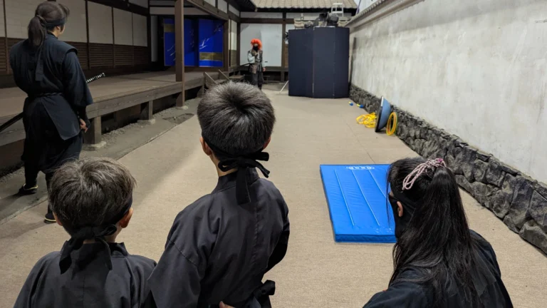 Children dressed as ninjas participating in a live ninja performance at Edo Wonderland in Nikko.
