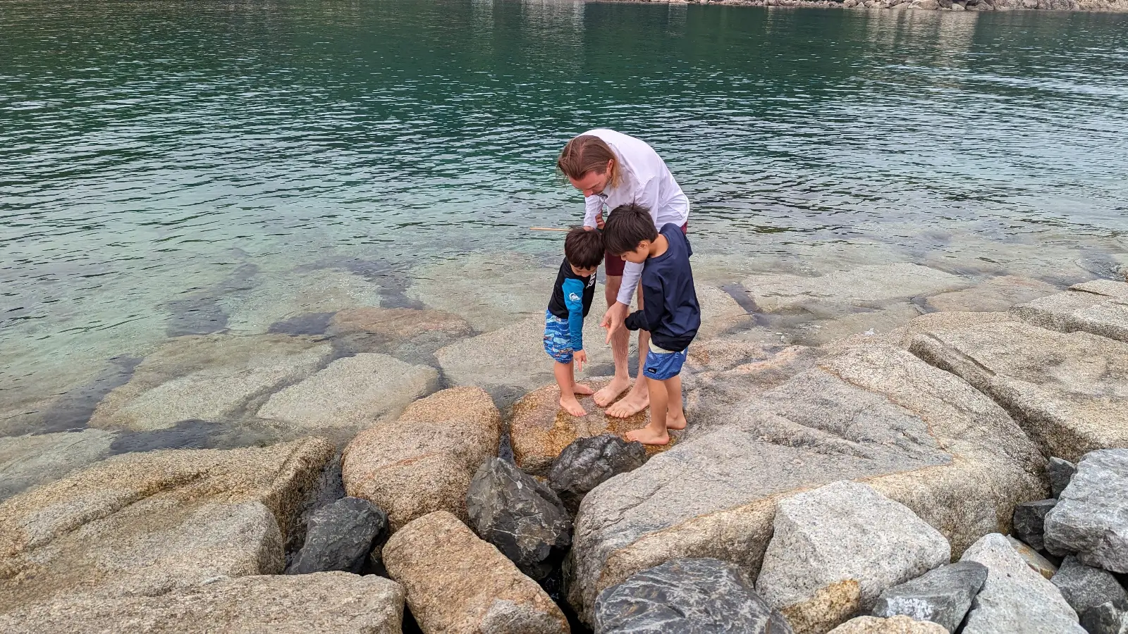 Papa, Luca & Nico explore tide pools along the rocky shoreline at Keya Beach, part of their Fukuoka itinerary with kids.
