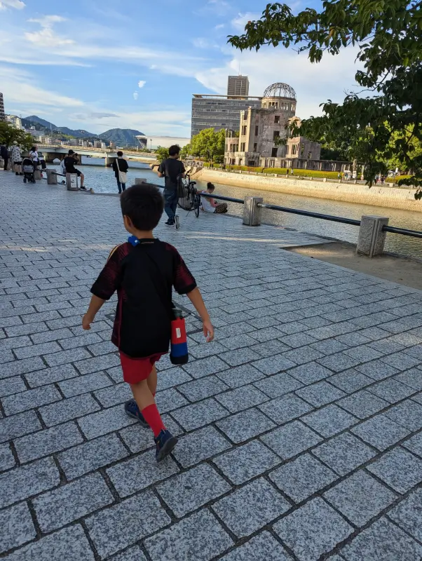Luca walking through Hiroshima Peace Park toward the Atomic Bomb Dome, an emotional and educational stop for meaningful family travel in Japan.