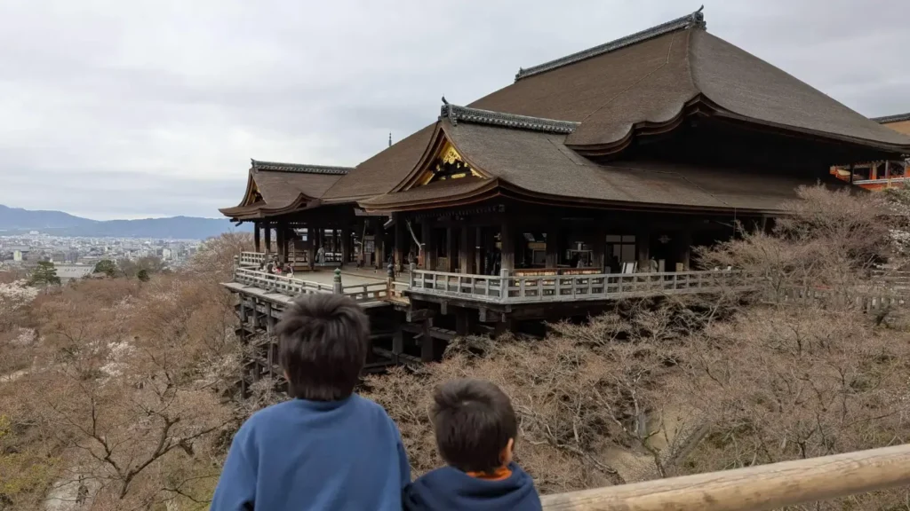 Luca and Nico look out over Kyoto's iconic Kiyomizu-dera temple, taking in centuries of history and culture. Experience Japan's heritage through meaningful family travel moments that spark curiosity and connection.