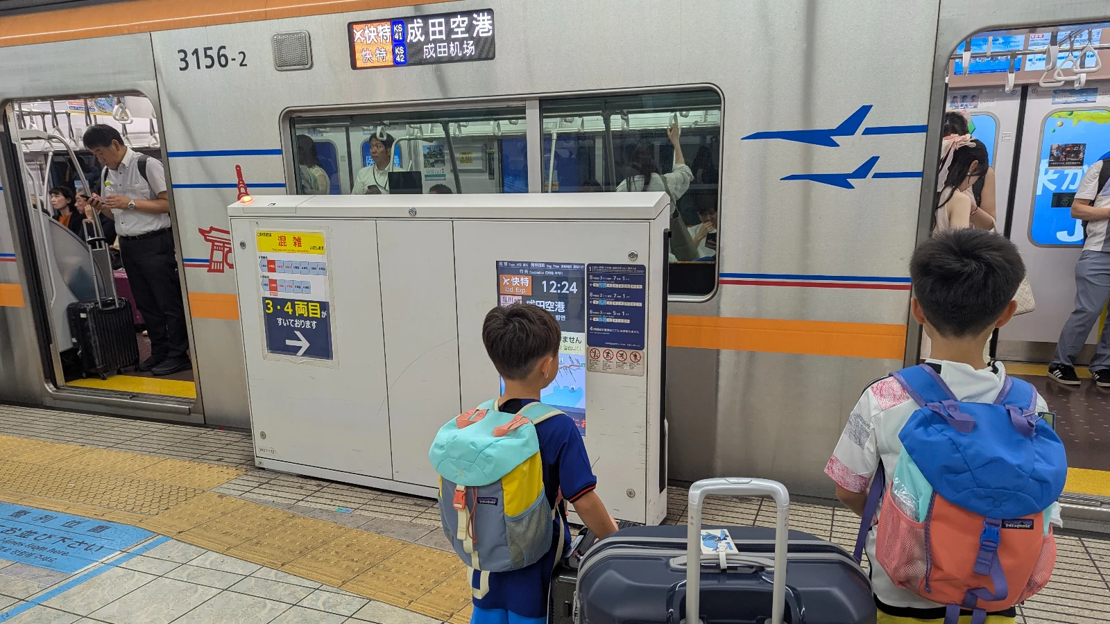 Family-friendly train platform at Haneda Airport with directional signage for Tokyo-bound transportation