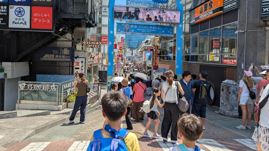 Families walking into Harajuku’s Takeshita Dori Street, a colorful neighborhood near Shibuya known for its fashion style, shops, and street snacks.