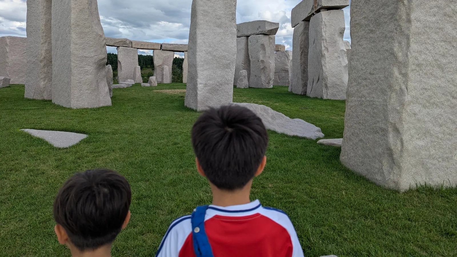 Two kids exploring the Stonehenge replica at Makomanai Takino Cemetery near the Hill of the Buddha in Sapporo, Japan.