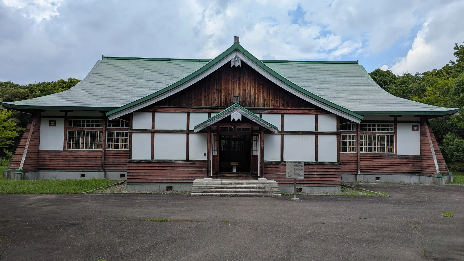 Exterior of a historic schoolhouse at the Historical Village of Hokkaido showing early 20th-century wooden architecture surrounded by trees.