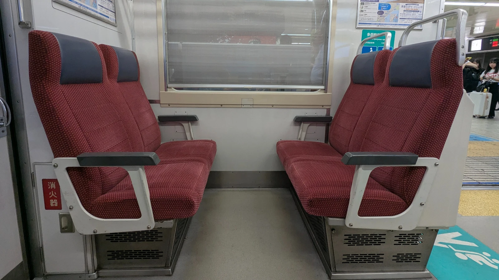 Facing seats inside a Japanese train, showing comfortable seating and legroom for passengers.