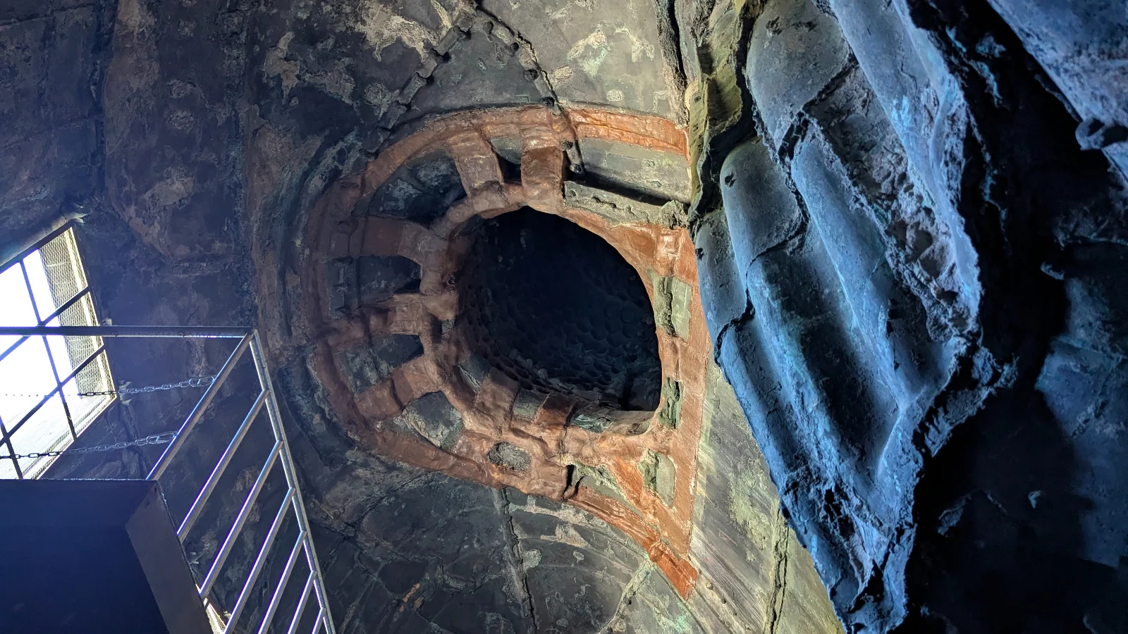 Interior view of the Kamakura Great Buddha statue showing bronze walls, lattice structure, and light from the entry platform.