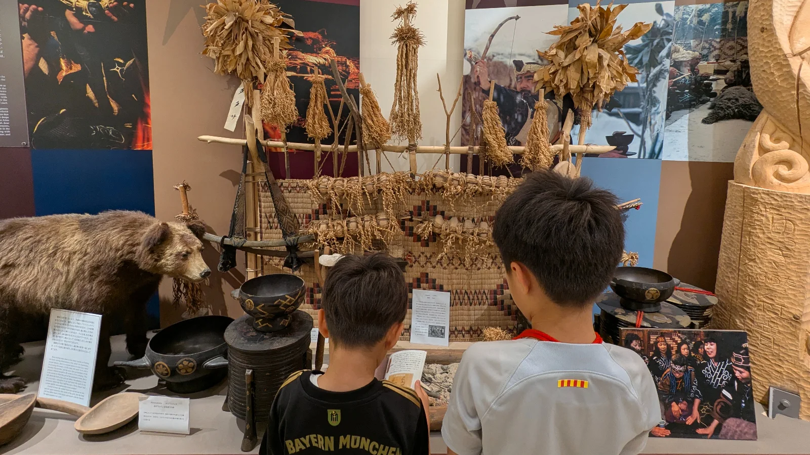 Two children explore traditional Ainu exhibits and artifacts inside the Kawamura Kaneto Ainu Memorial Museum in Asahikawa, Japan.