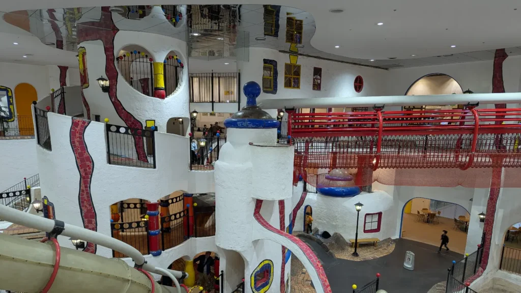 Colorful multi-level climbing towers, tunnels, and slides at Kids Plaza Osaka indoor playground, one of the best indoor playgrounds in Osaka for kids.