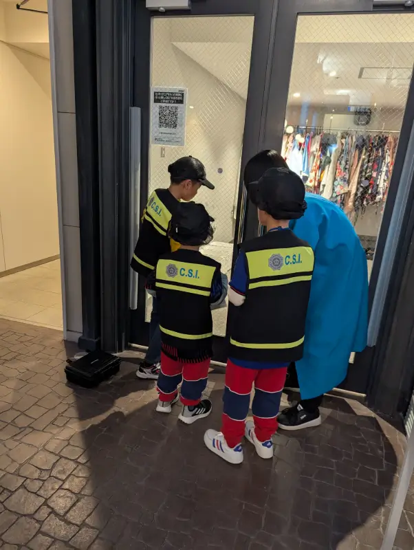 Kids solving a mystery as forensic investigators at KidZania Fukuoka, an engaging and educational activity for families visiting Japan.