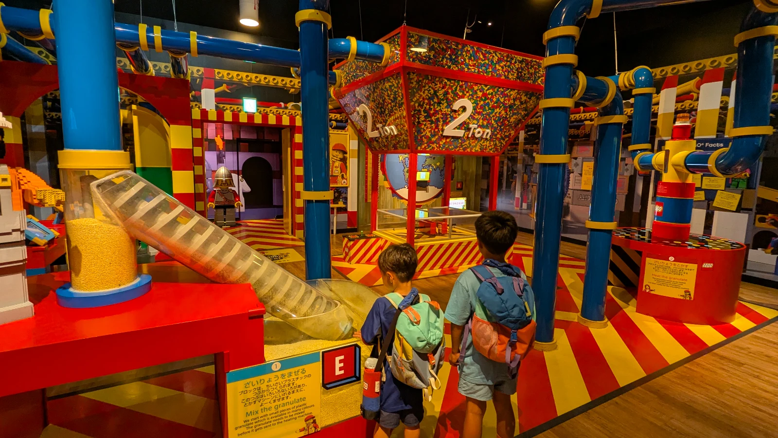 Children watching the LEGO Factory Adventure exhibit at LEGOLAND Discovery Center Tokyo, learning how LEGO bricks are made through colorful interactive machines.