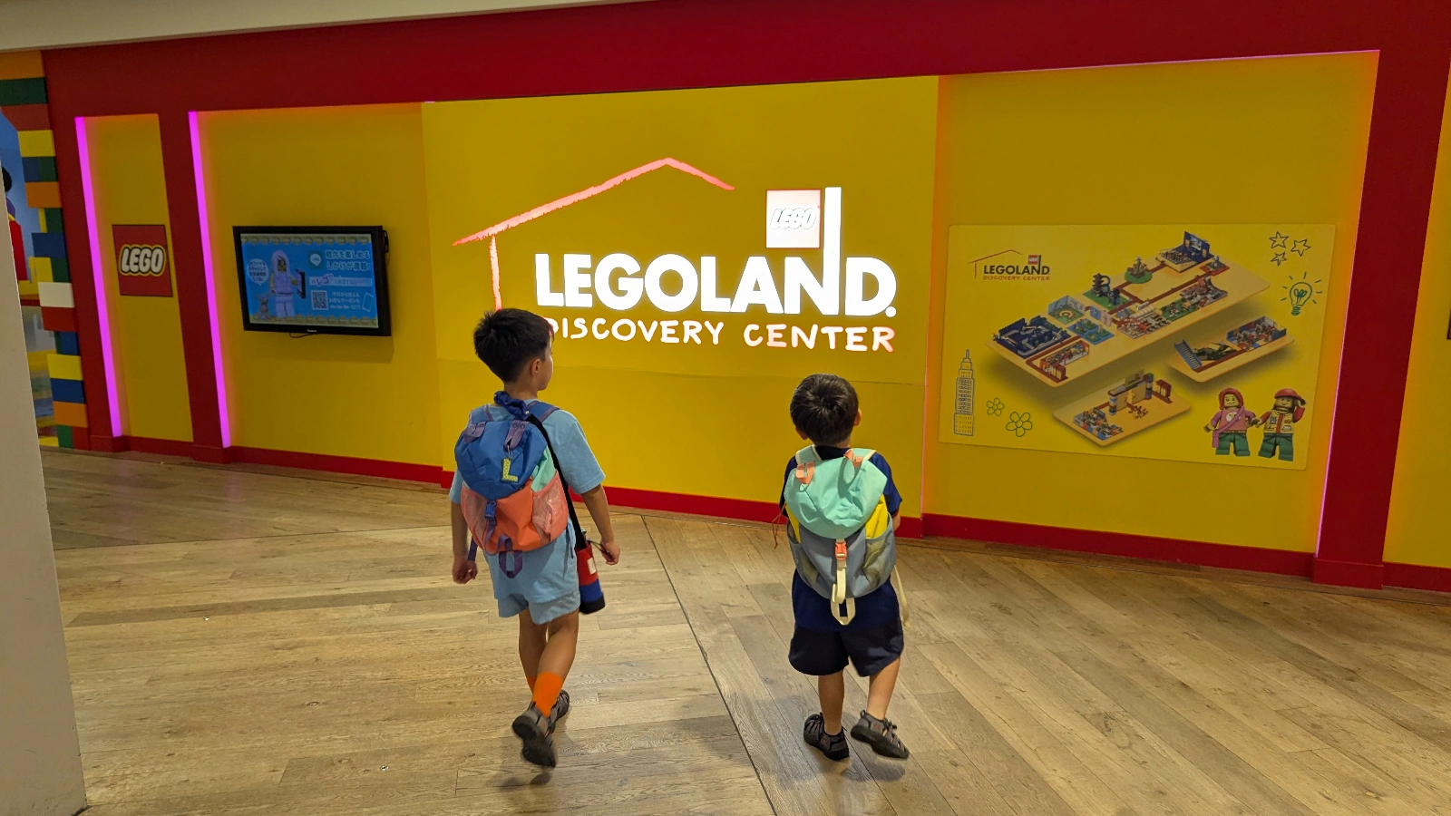 Luca & Nico with backpacks walking toward the LEGOLAND Discovery Center Tokyo entrance in Odaiba.