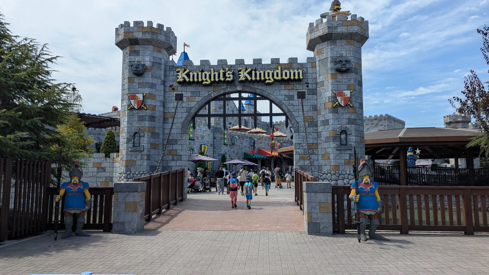 Luca and Nico walk in through the stone castle gate of Knight's Kingdom at LEGOLAND Japan in Nagoya.