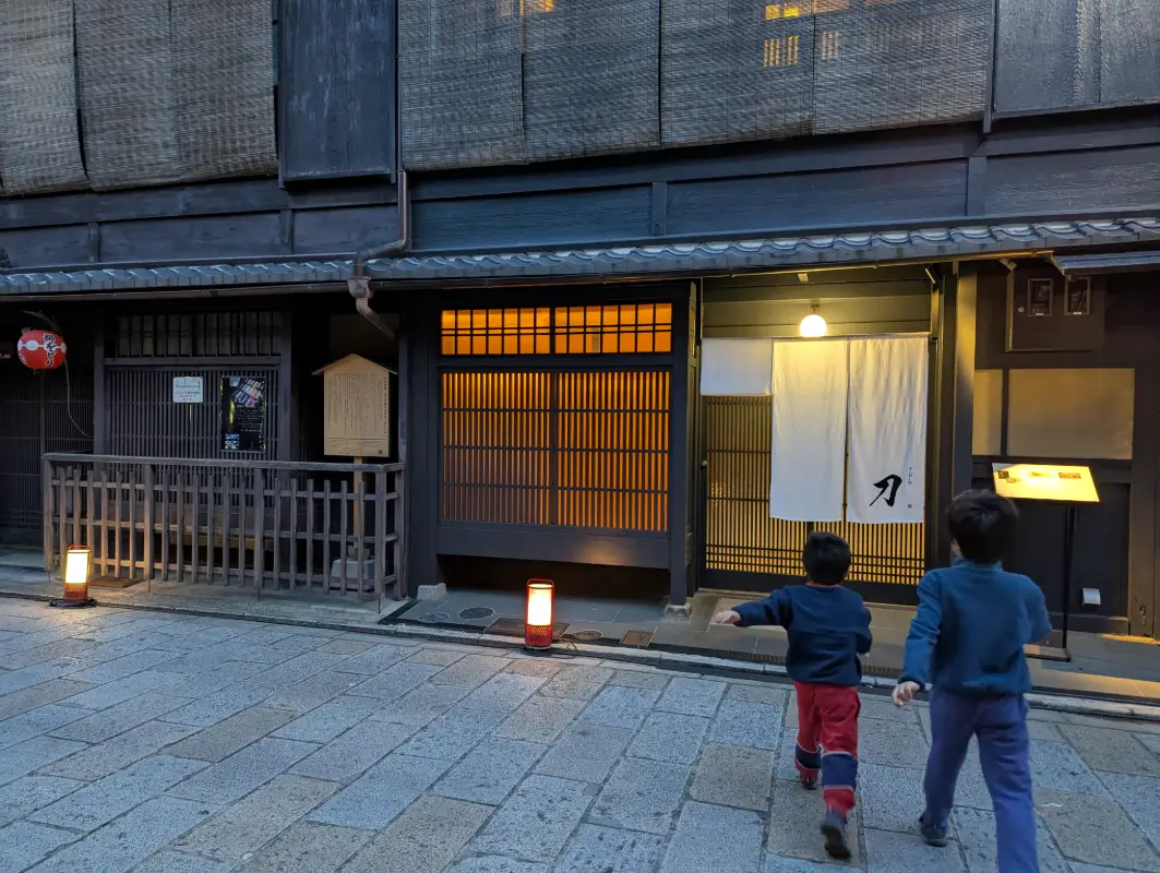 Luca & Nico walking through Gion’s historic lantern-lit streets during an evening adventure on their Kyoto itinerary with kids.