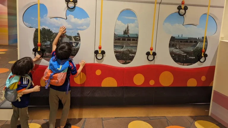 Luca and Nico reach for Mickey-shaped handholds on the Tokyo Disney Resort monorail.
