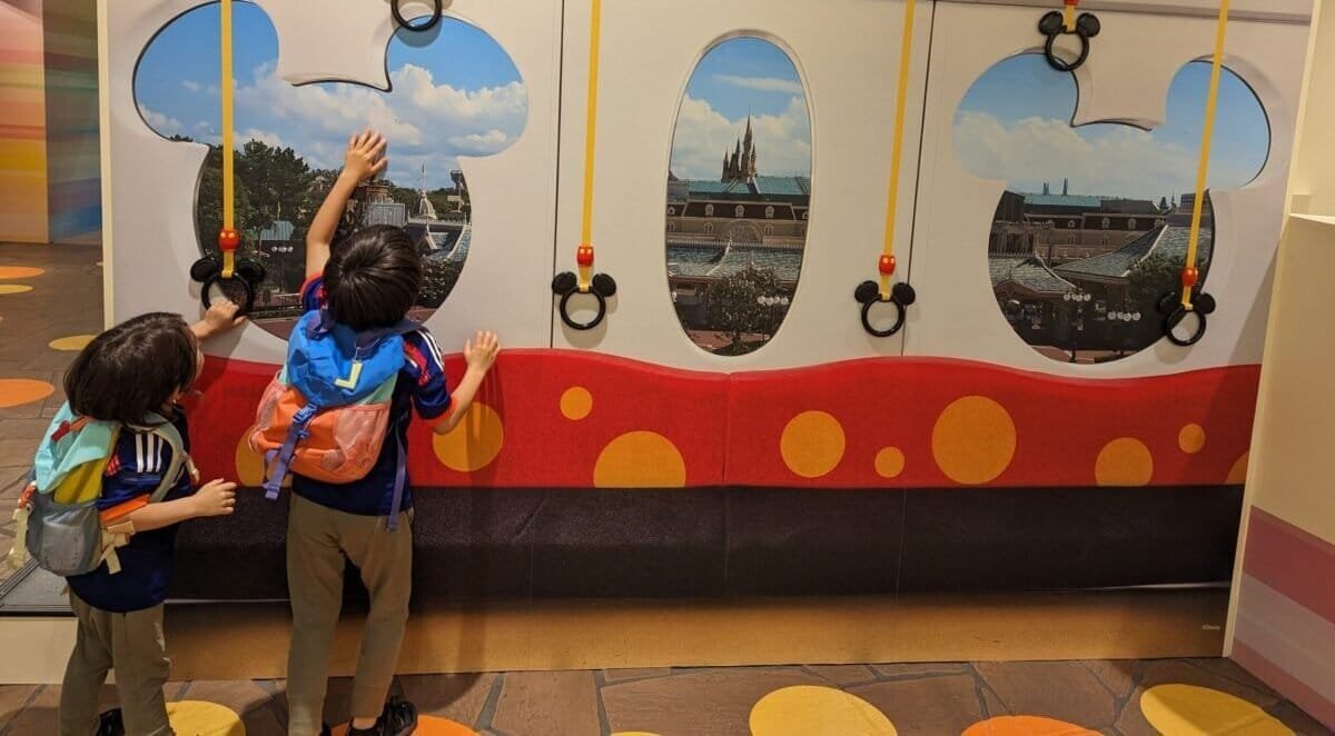 Luca and Nico reach for Mickey-shaped handholds on the Tokyo Disney Resort monorail.