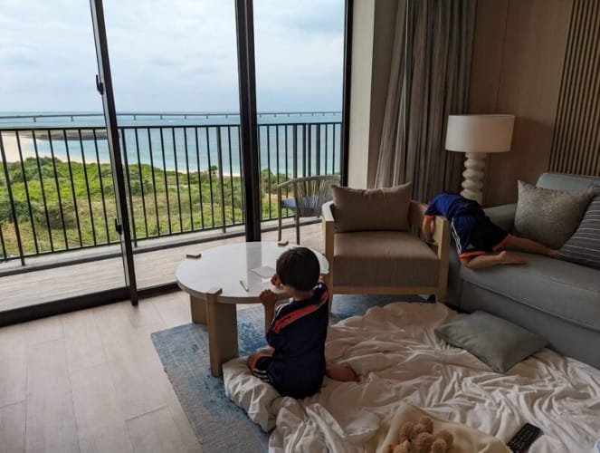 Luca & Nico relaxing in their upgraded suite at the Hilton Miyakojima in Miyako Island, enjoying ocean views and cozy downtime during their family vacations in Japan.