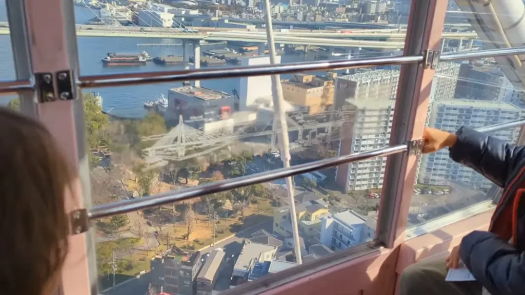 Luca and Nico riding the Tempozan Ferris Wheel in Osaka, looking out over the city and bay on their spring family travel itinerary.