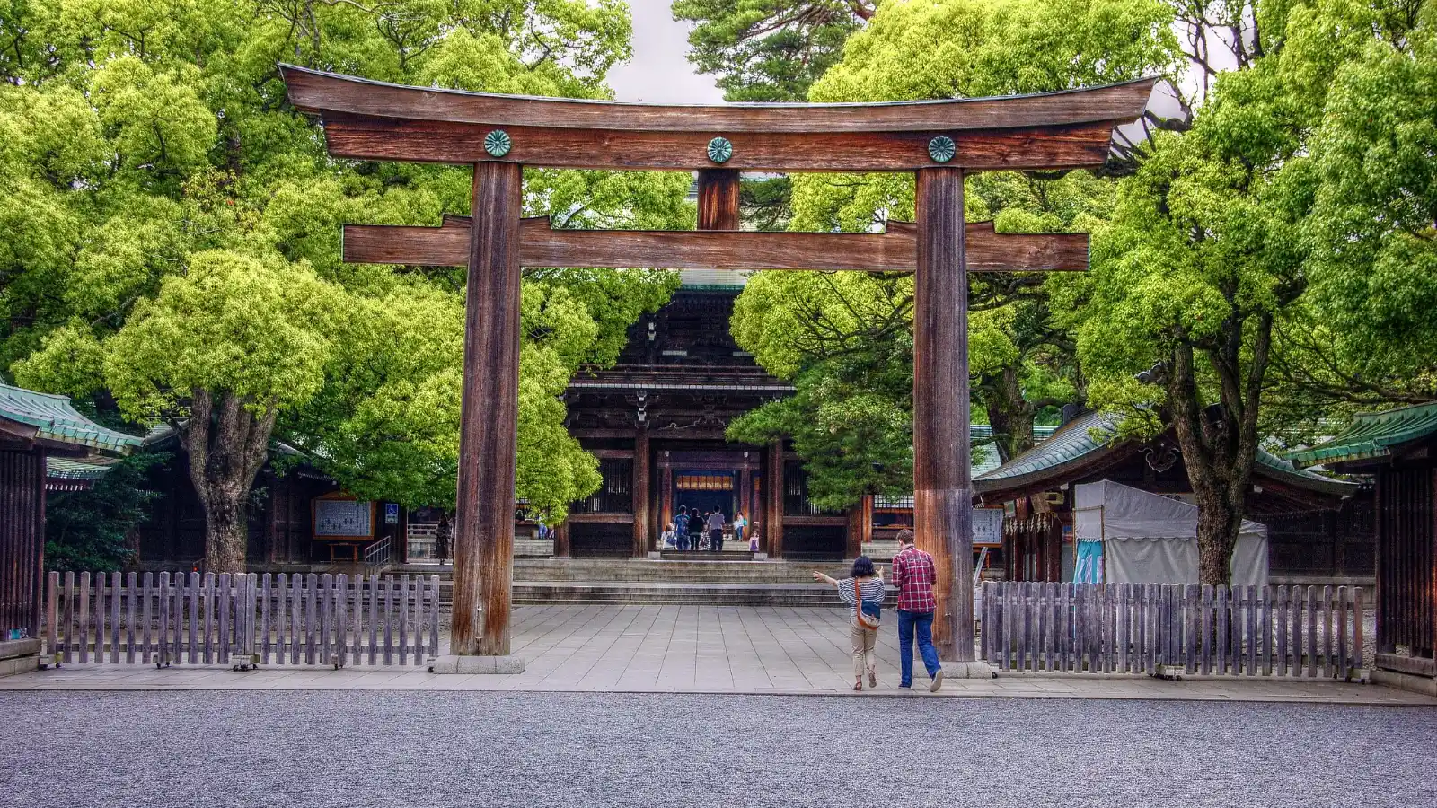 Family walking through the giant torii gate at Meiji Shrine location in Tokyo, a peaceful and family-friendly destination also known as Meiji Temple.