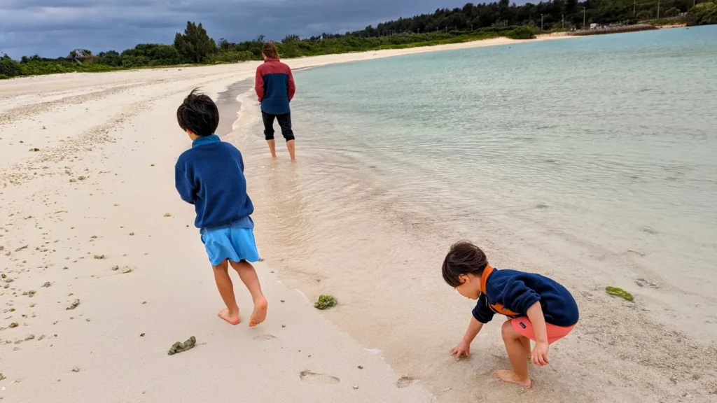 Luca and Nico exploring a quiet beach on Miyakojima Island with their family, part of a playful mission adventure.