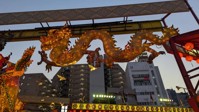 Golden dragon lantern glowing over Nagasaki city buildings during the Nagasaki Lantern Festival in Japan, a top family-friendly winter event.