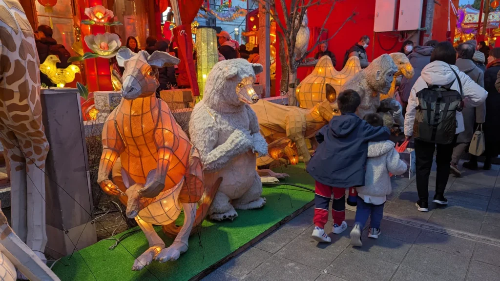 Luca & Nico exploring glowing zodiac animal lanterns during the Nagasaki Lantern Festival, engaging in a family-friendly scavenger hunt to learn about the Chinese Zodiac legends.
