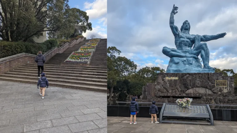 Luca & Nico visiting Nagasaki Peace Park with family, walking toward the Peace Statue and the memorial steps decorated with flowers.