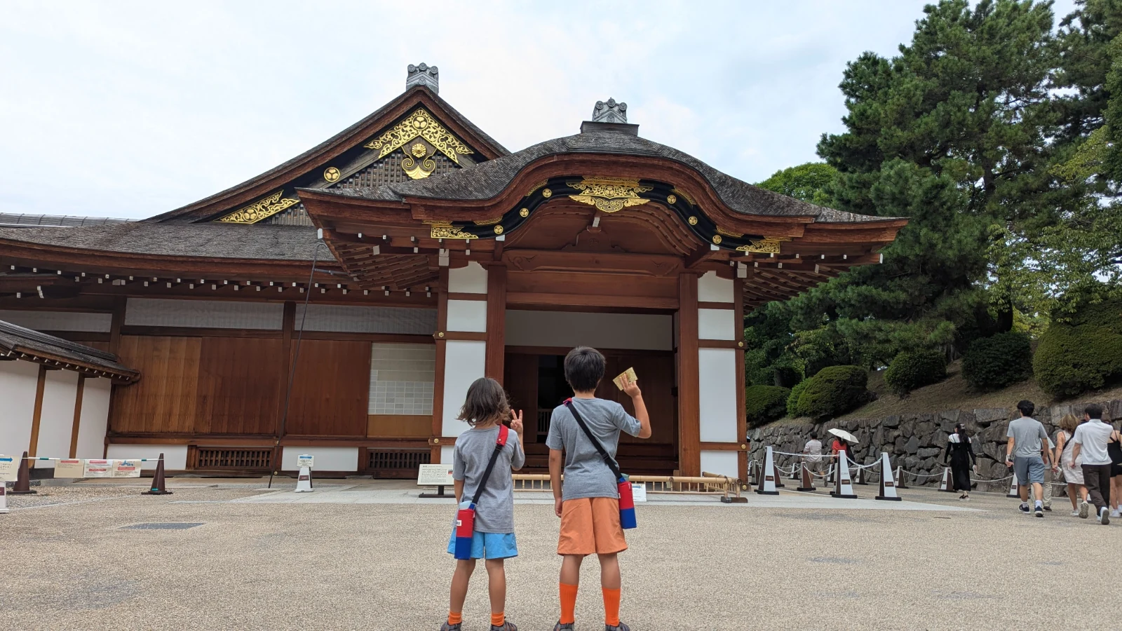 Luca and Nico stand before the curved-gable entrance of the Hommaru Palace at Nagoya Castle in Nagoya.