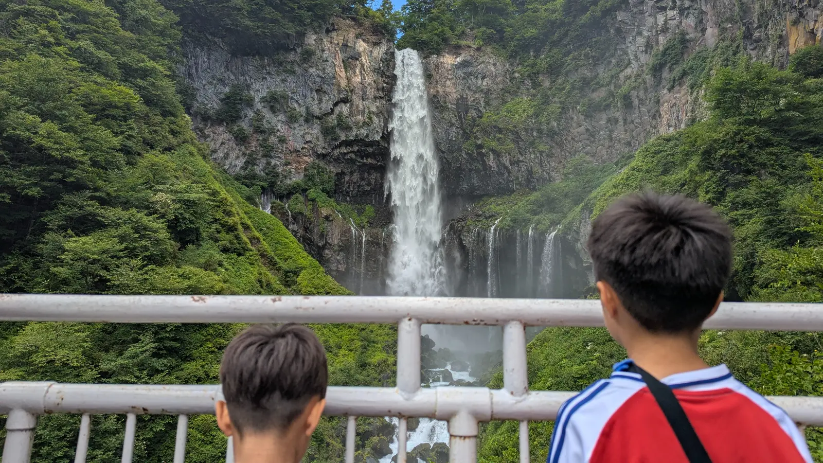 Two children looking at Kegon Falls in Nikko, one of the top attractions for families visiting Japan.