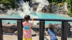 Luca and Nico exploring the steaming blue hot spring at Beppu’s Hell Tour, one of the top attractions in Oita with kids.