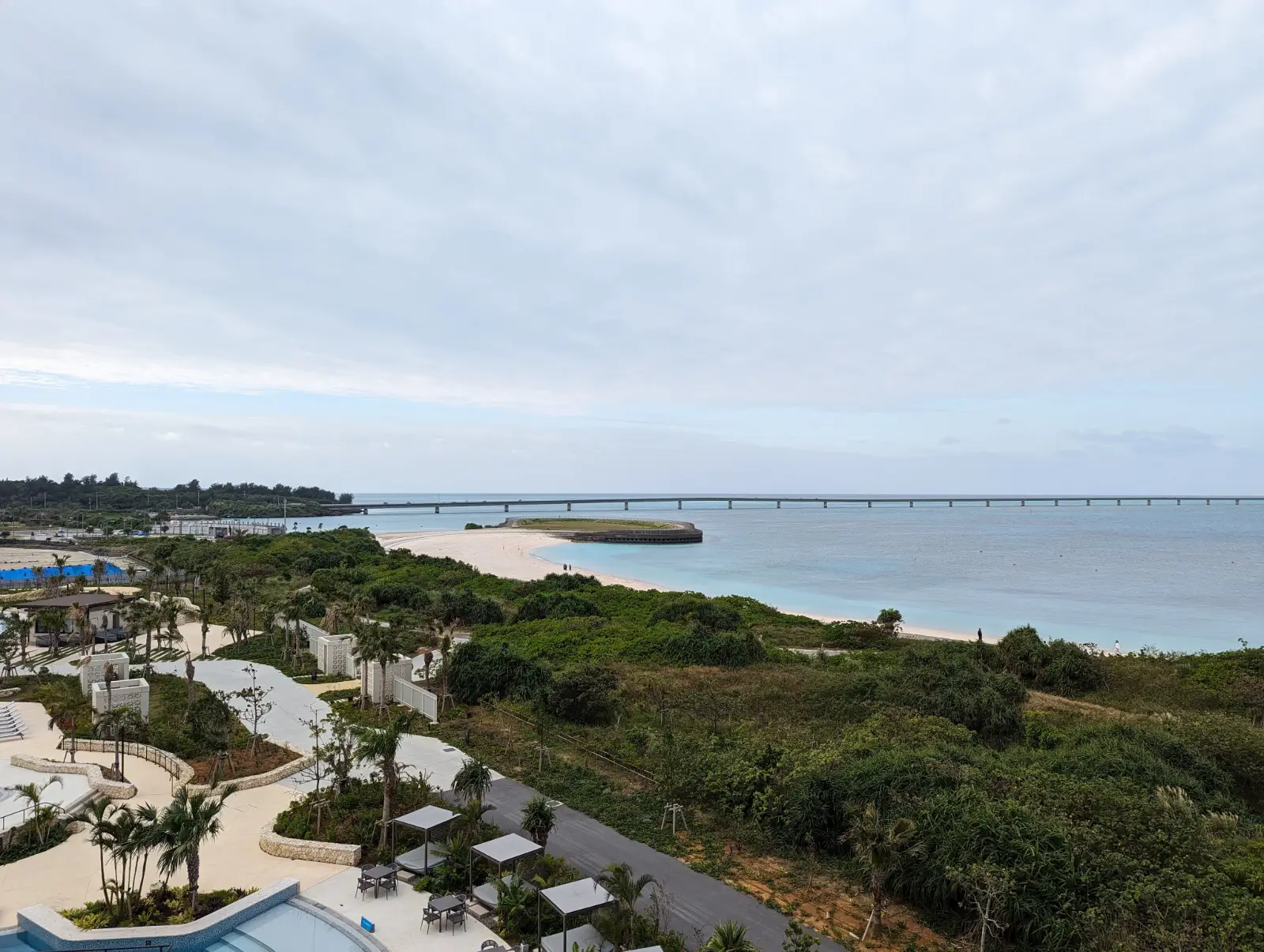 Stunning view of Miyakojima's (Miyako Island) tropical coastline and Yonaha Maehama Beach from the Hilton Miyakojima Resort, showcasing pristine waters and lush greenery, perfect for a family-friendly getaway.