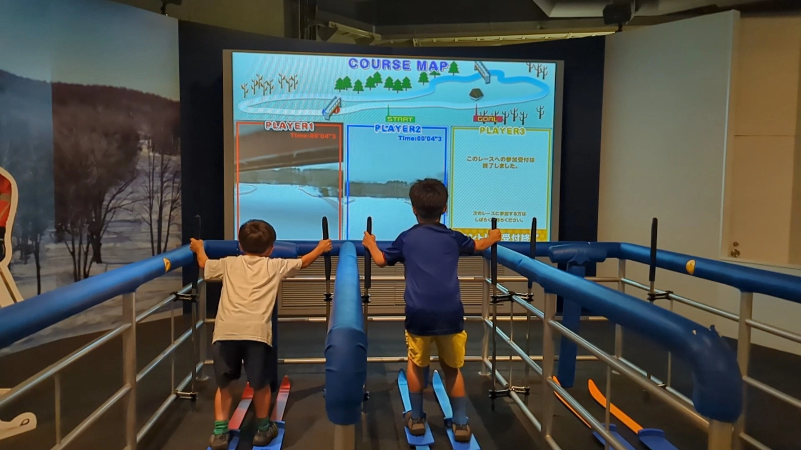 Kids racing on the cross-country skiing simulator inside the Sapporo Olympic Museum, an interactive winter sports experience in Japan.