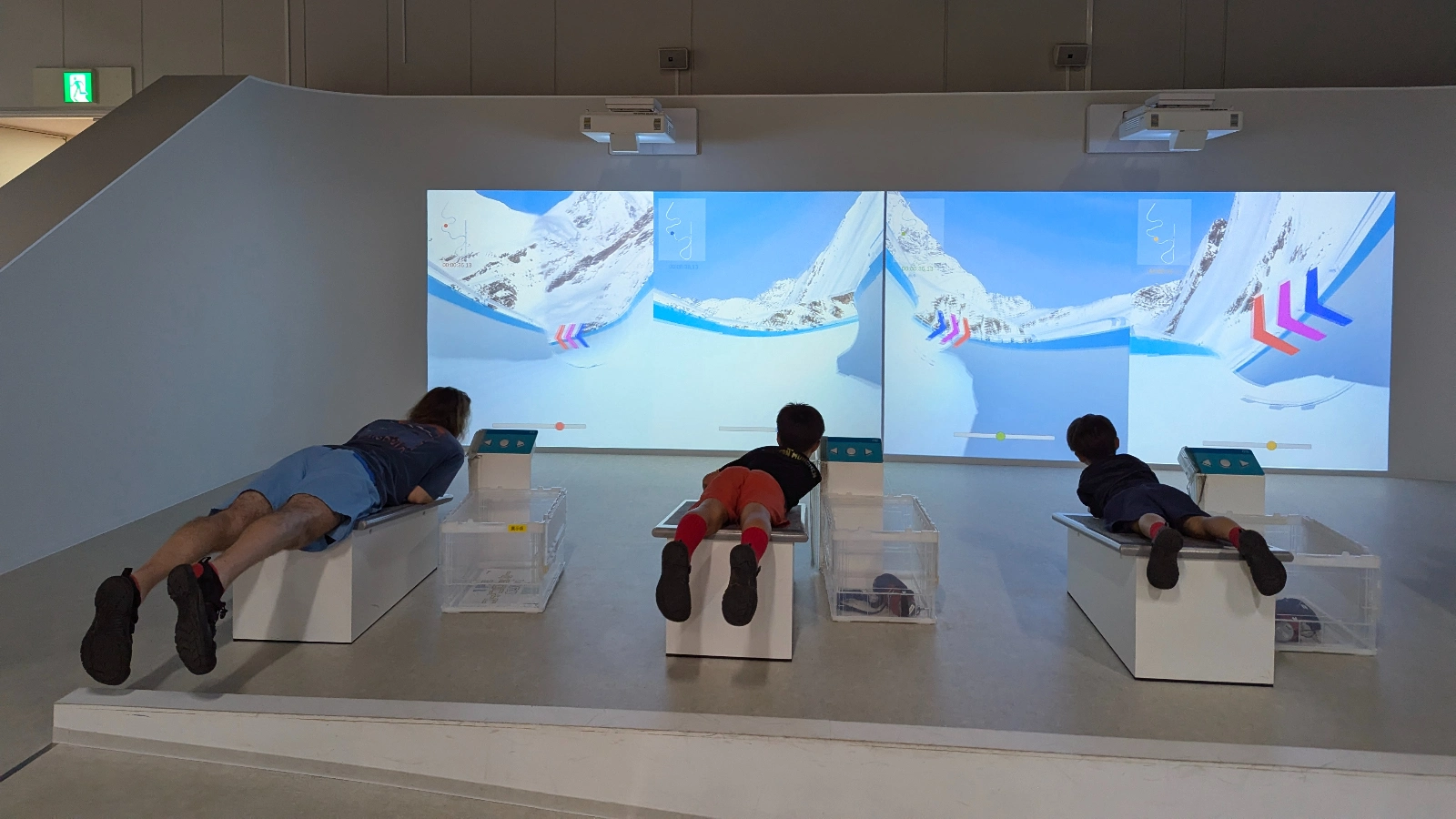 Kids and adults race side by side in the luge simulation game at Sapporo Science Center, combining sports, science, and friendly competition.