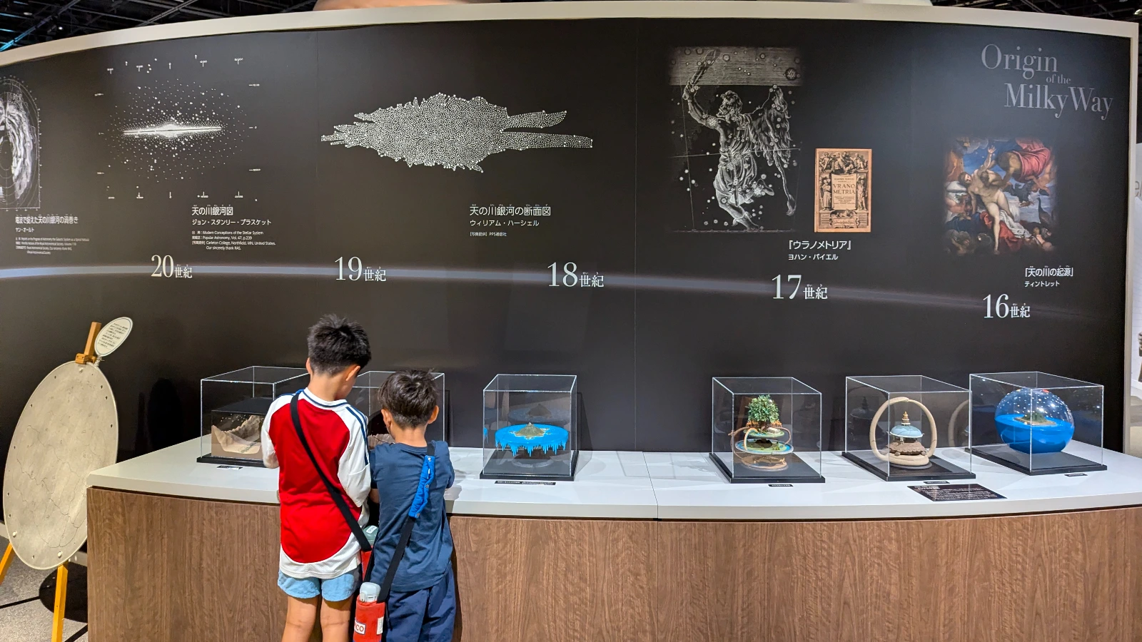 Kids looking at space and galaxy exhibits inside Sendai Astronomical Observatory, an interactive science destination for families.