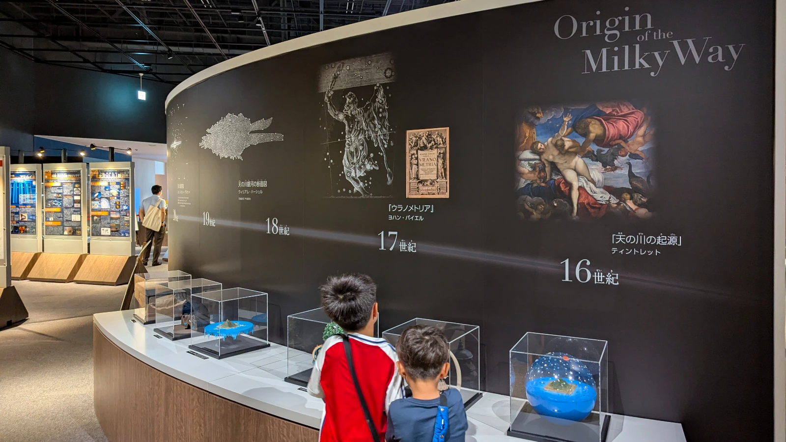 Two children study miniature models and astronomy displays at the Sendai Astronomical Observatory, a popular science museum for kids in Japan.