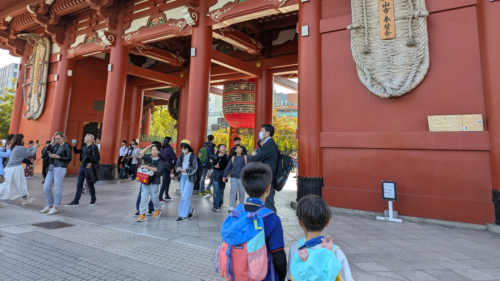Luca and Nico standing near the entrance gate of Senso-ji Temple in Asakusa, showing the busy crowds families can expect when visiting this popular area
