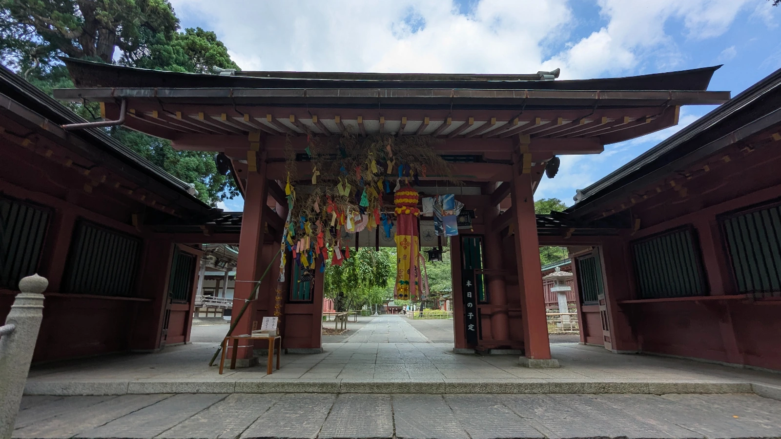 The decorated inner gate of Shiogama Shrine in Sendai, Miyagi, featuring colorful hanging ornaments and wooden beams in summer.