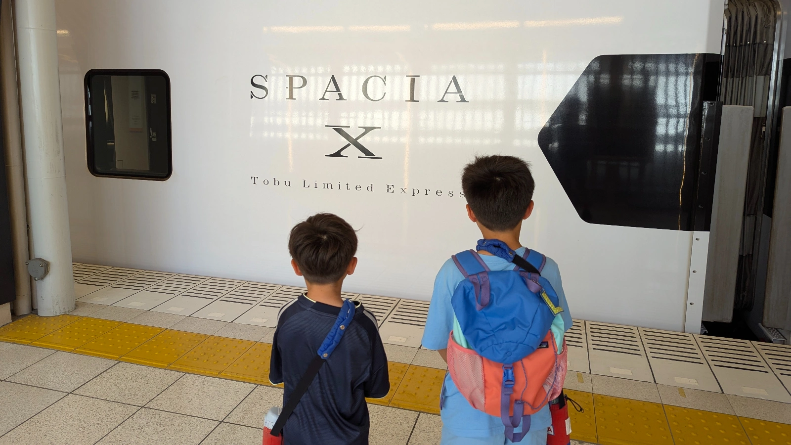 Luca & Nico standing on the platform in front of the Tobu Spacia X limited express train to Nikko.