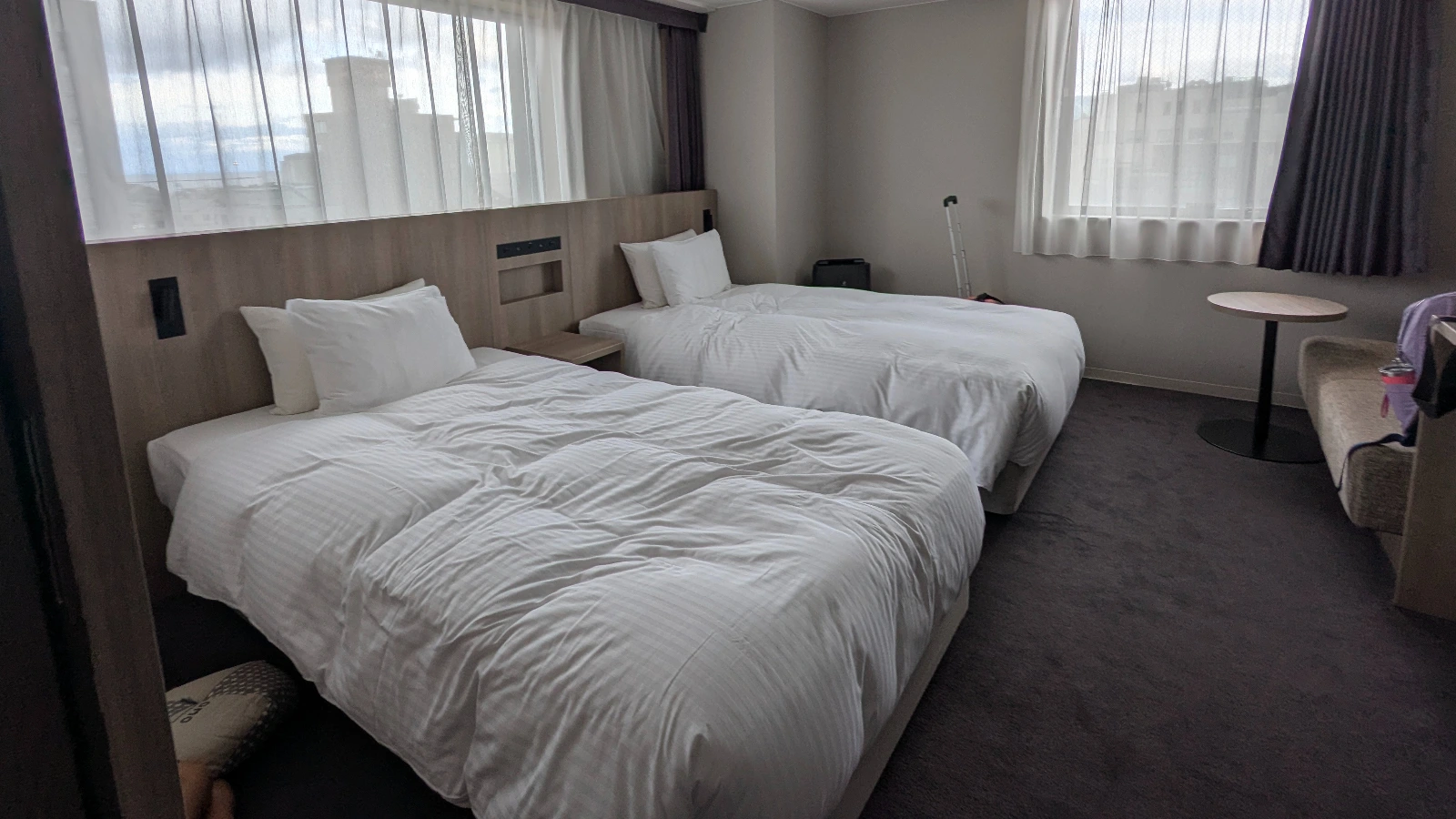 A spacious family-friendly hotel room in Japan with two twin beds and seating area.