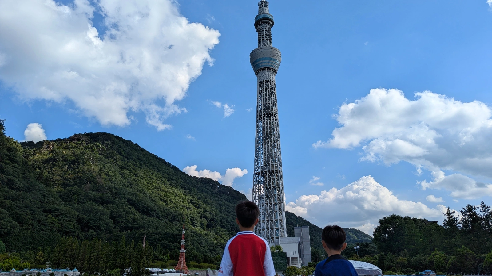 Two kids looking up at the miniature Tokyo Skytree replica at Tobu World Square in Nikko, Japan.