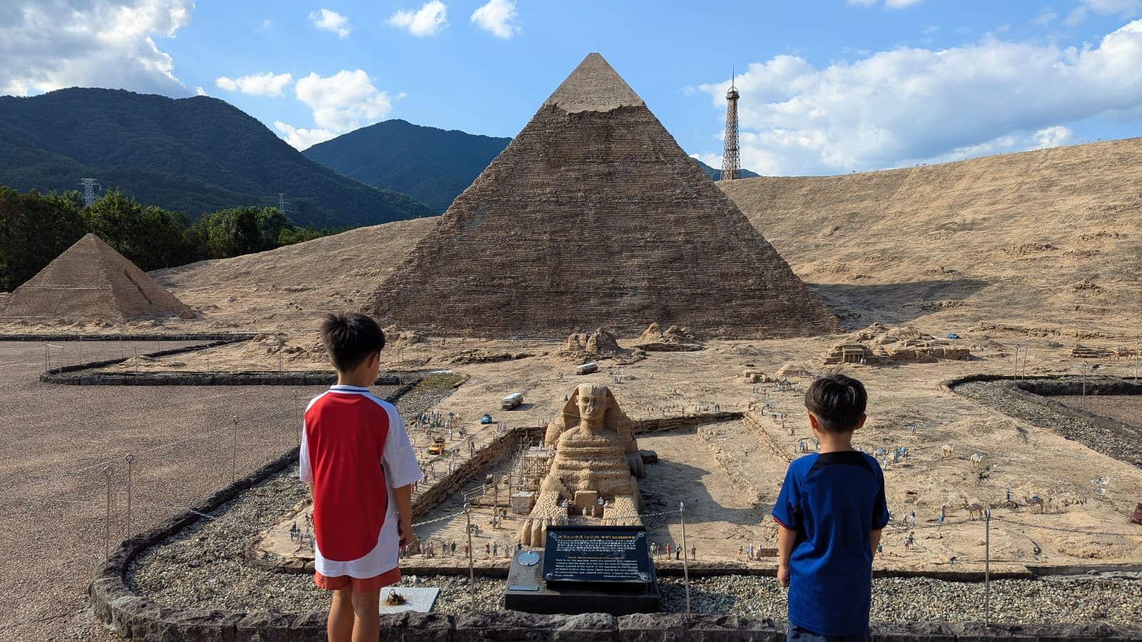 Two children viewing miniature pyramids and sphinx at Tobu World Square in Nikko, a family-friendly attraction.