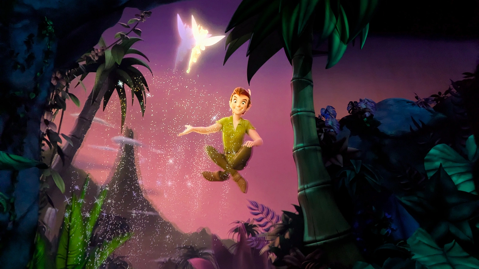 Peter Pan floats in midair surrounded by sparkling pixie dust and lush jungle scenery inside one of Tokyo DisneySea’s Fantasy Springs rides.
