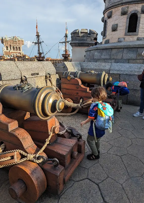 Luca and Nico explore the fortress cannons at Tokyo DisneySea, imagining pirate battles and ancient secrets during their family adventure.