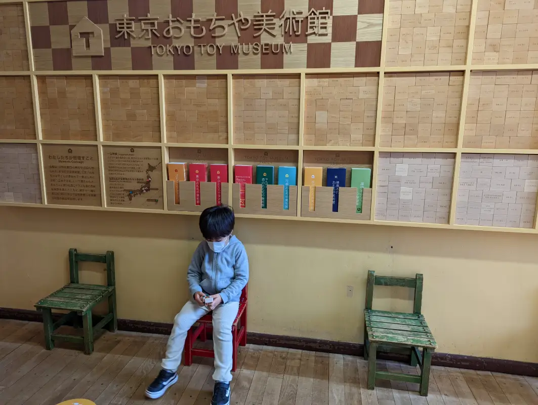 Luca sitting at Tokyo Toy Museum, exploring traditional Japanese toys in a family-friendly setting.